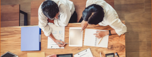 Ein Auditor und ein Mitarbeiter besprechen im internen Audit einen Prozess