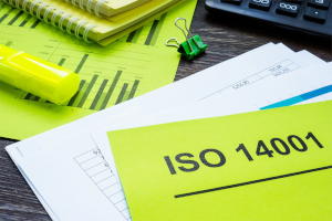 Grüne ISO-14001-Unterlage mit Dokumenten, Markierungen und Diagrammen – steht für Umweltmanagement und Auditvorbereitung.