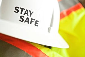 Weißer Helm mit „Stay Safe“ auf Warnschutzjacke – Symbol für Arbeitssicherheit und Gesundheitsschutz nach ISO 45001 Audit.