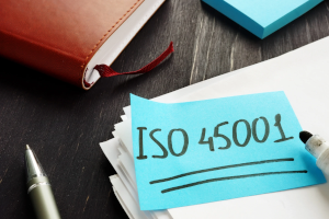 Haftnotizzettel mit ISO 45001 auf Schreibtisch, daneben Marker, Notizbuch – symbolisiert Arbeitsschutz-Audit.