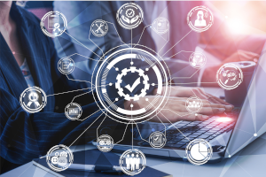 Geschäftspersonen arbeiten am Laptop, umgeben von digitalen Symbolen zu Qualitätsmanagement, Compliance, Prozessen und Auditierung.